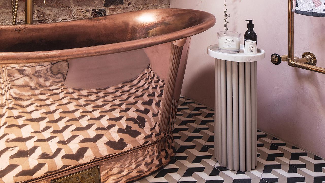 small bathroom colour ideas: copper bath and pink pedestal table 