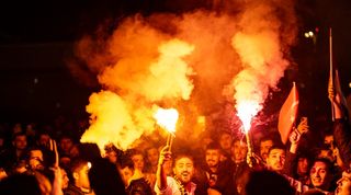 Turkish fans await the arrival of Fenerbahce at the airport in Istanbul after their team's postponed Turkish Super Cup clash against city rivals Galatasaray in December 2023.