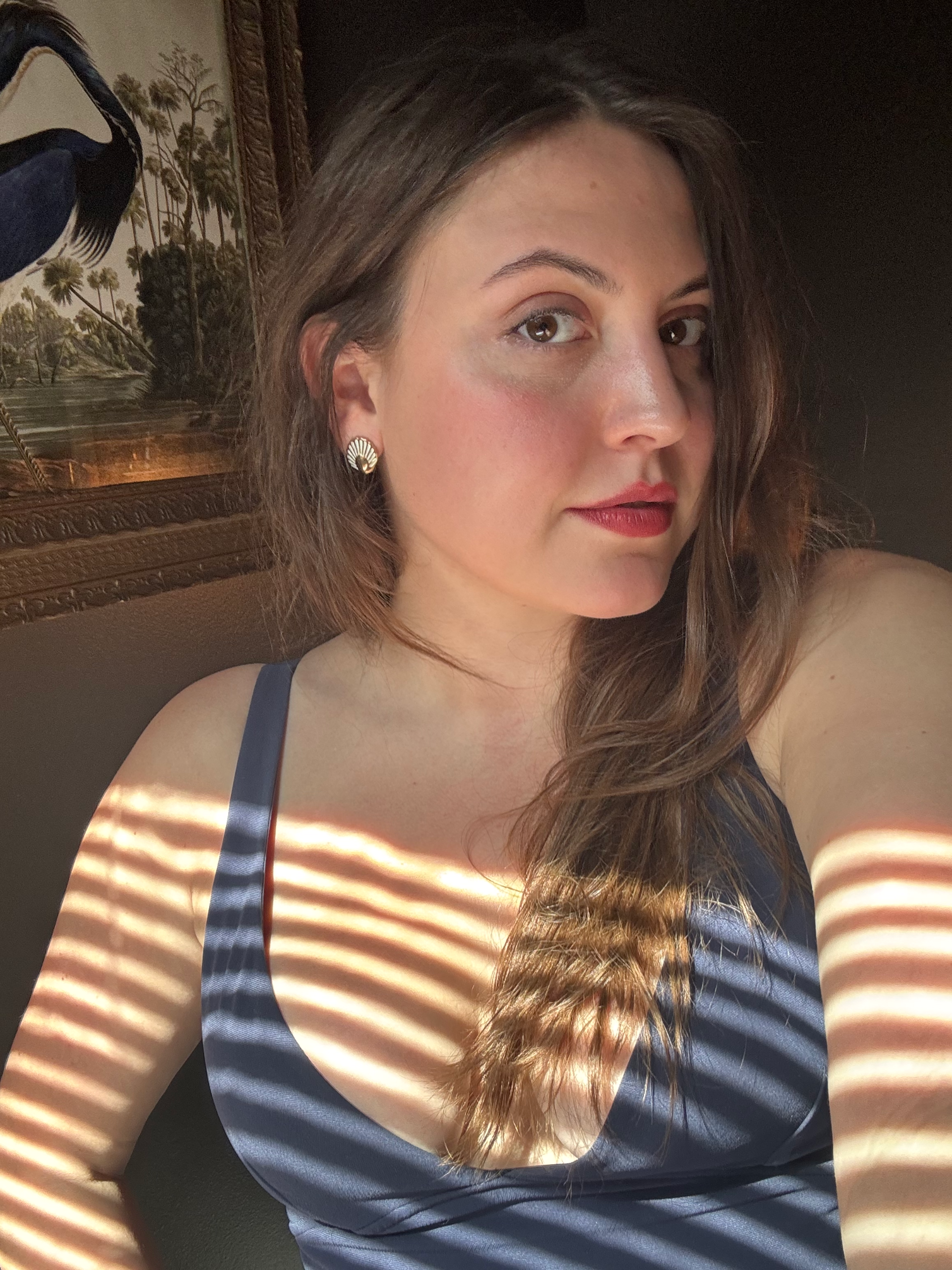 a white woman with brown hair in a blue top with red lipstick