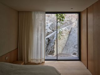 bedroom with large window and sheer curtains in mexican house