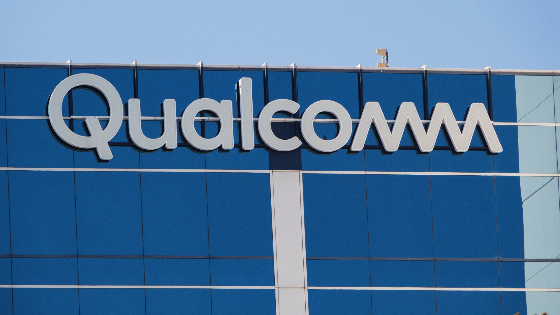 A Qualcomm logo is displayed on a building on their campus