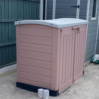 pink painted storage bin in garden