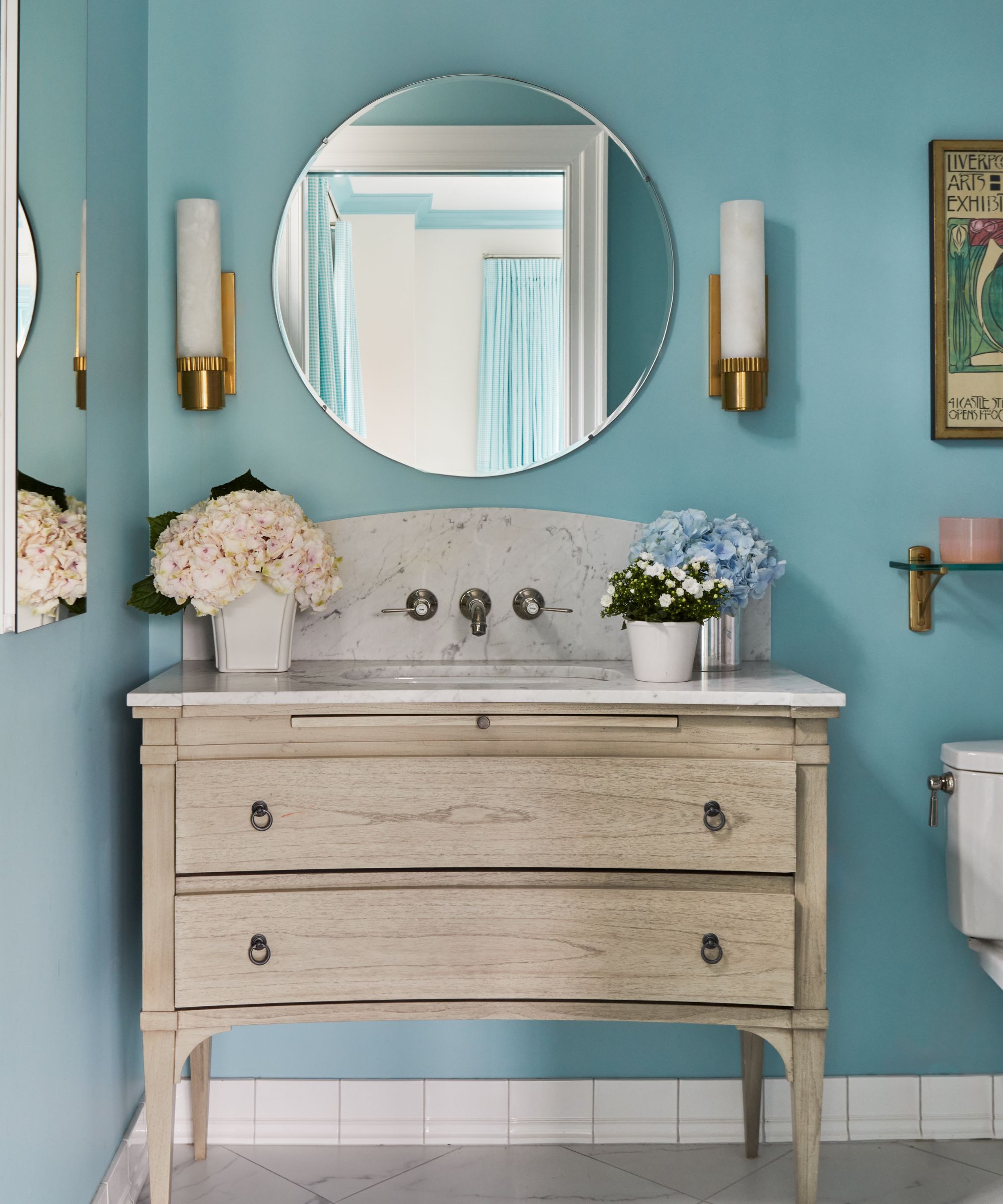 Bathroom with vanity unit, round mirrors, light blue walls