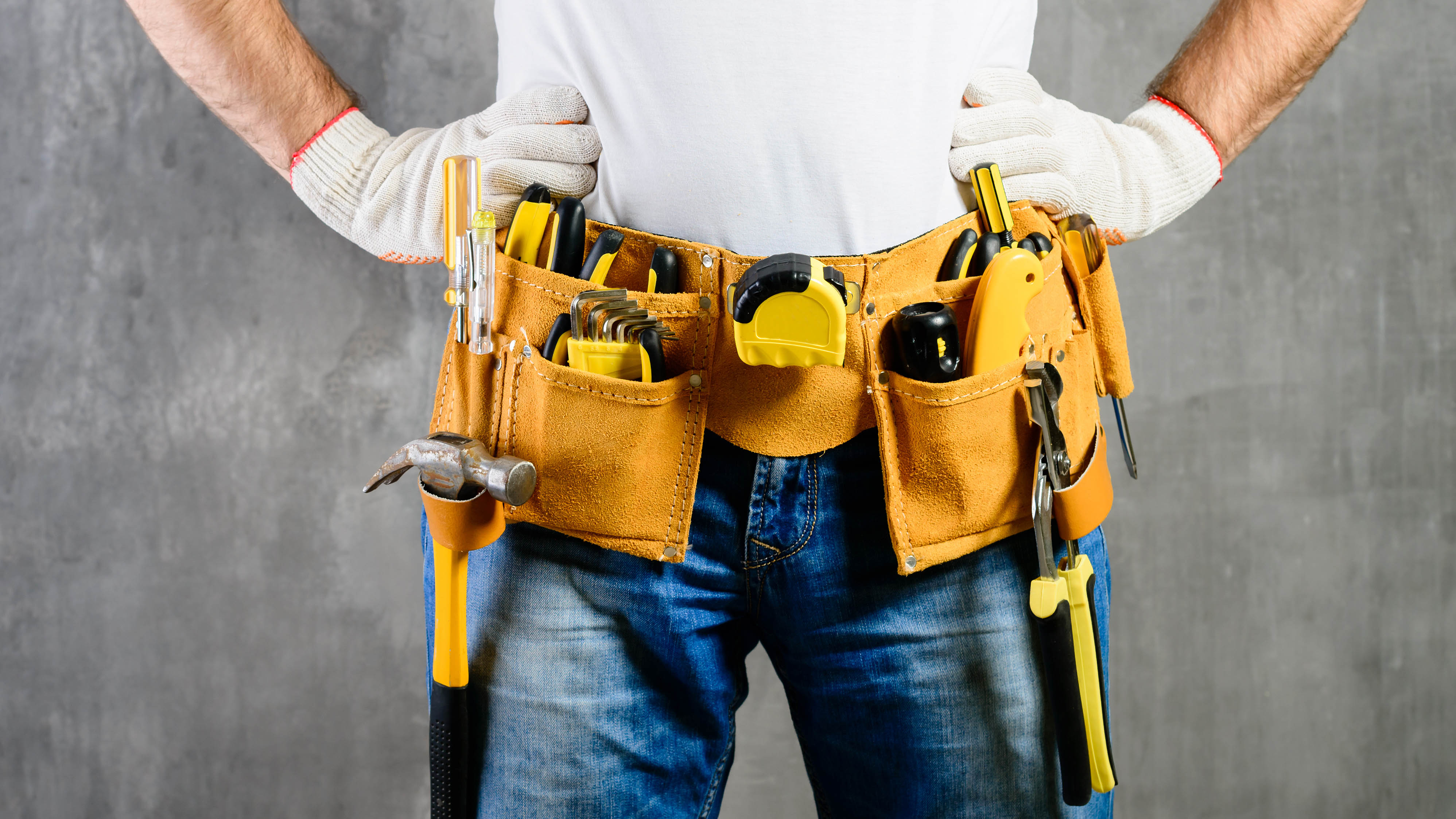 A professional handyman carrying tools around his waist