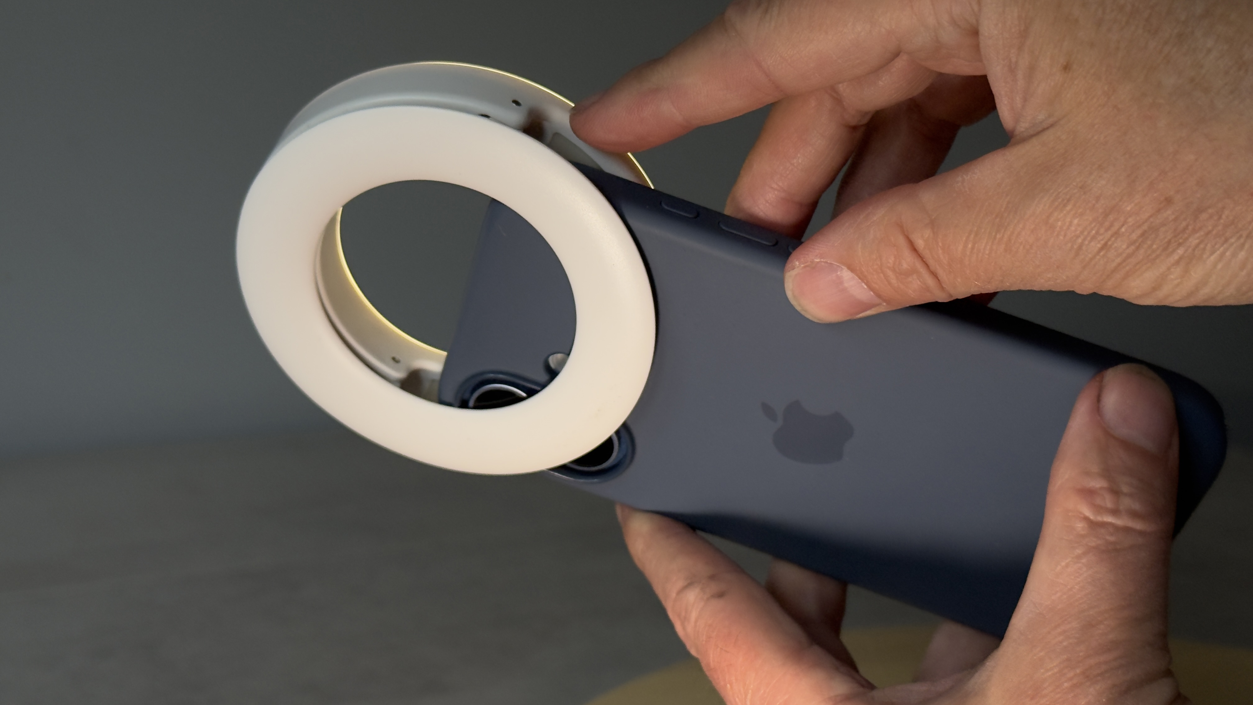 Shot of the Selfie Ring Light clipped to an iPhone 17. The LED's clip overlaps and obscures the two rear cameras on the back of the iPhone.