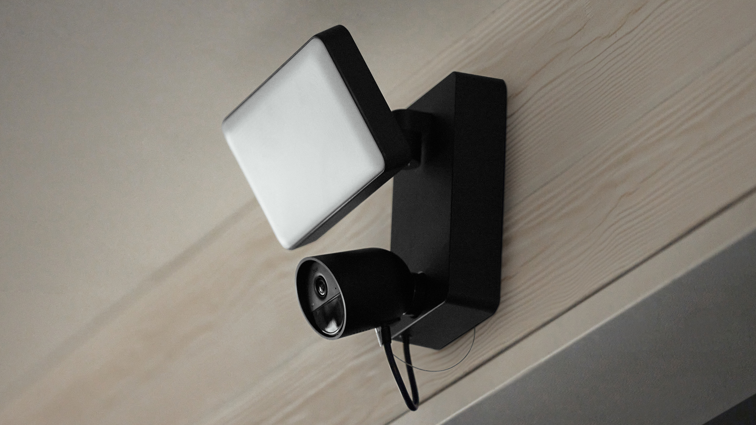 The Philips Hue Secure Floodlight camera on a wall