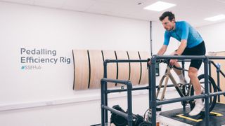 W manin a blue jersey rides a static bike in a lab