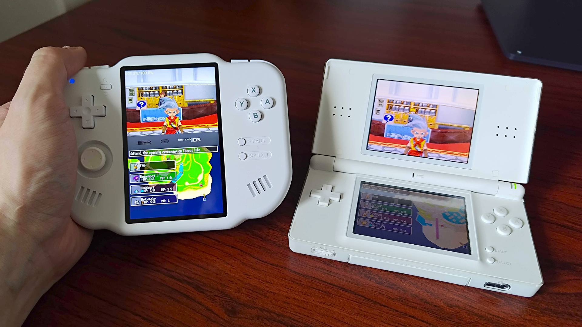 Hand holding MagicX Zero 40 handheld on left and Nintendo DS Lite on right with both running Dragon Quest Monsters Joker and main character looking towards camera.