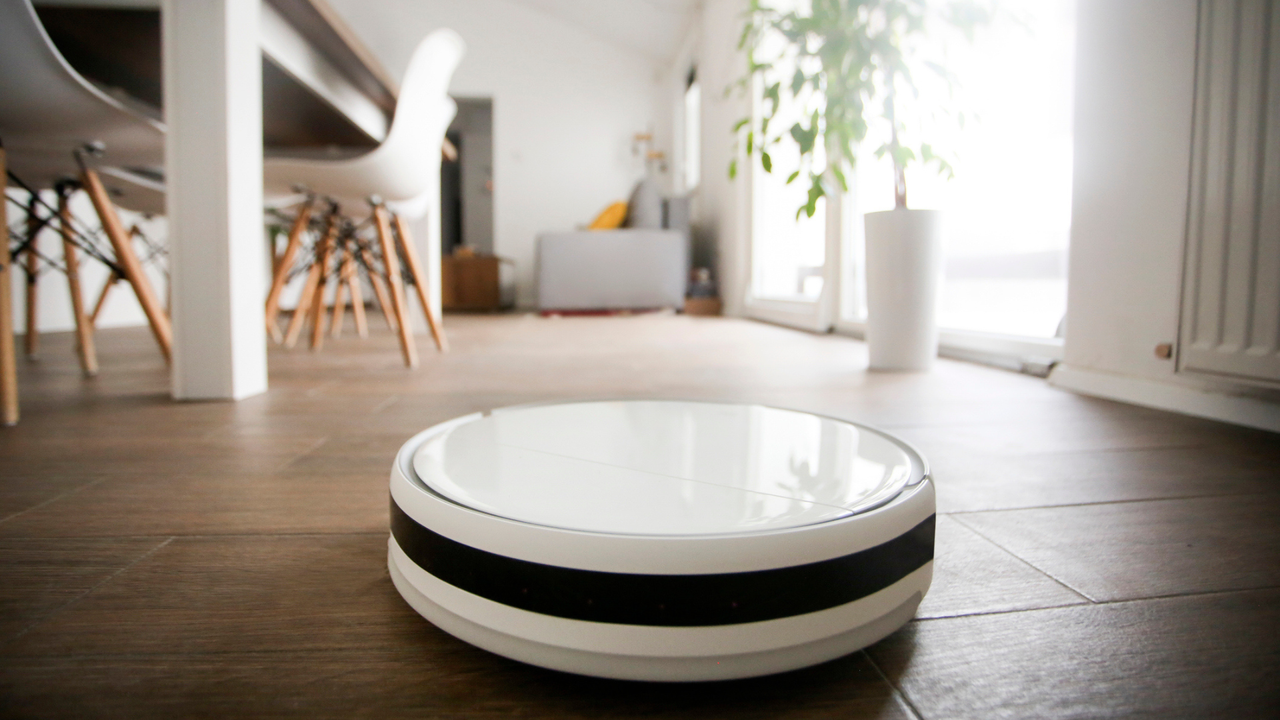 Robot vacuum cleaner cleaning a dining room in a house