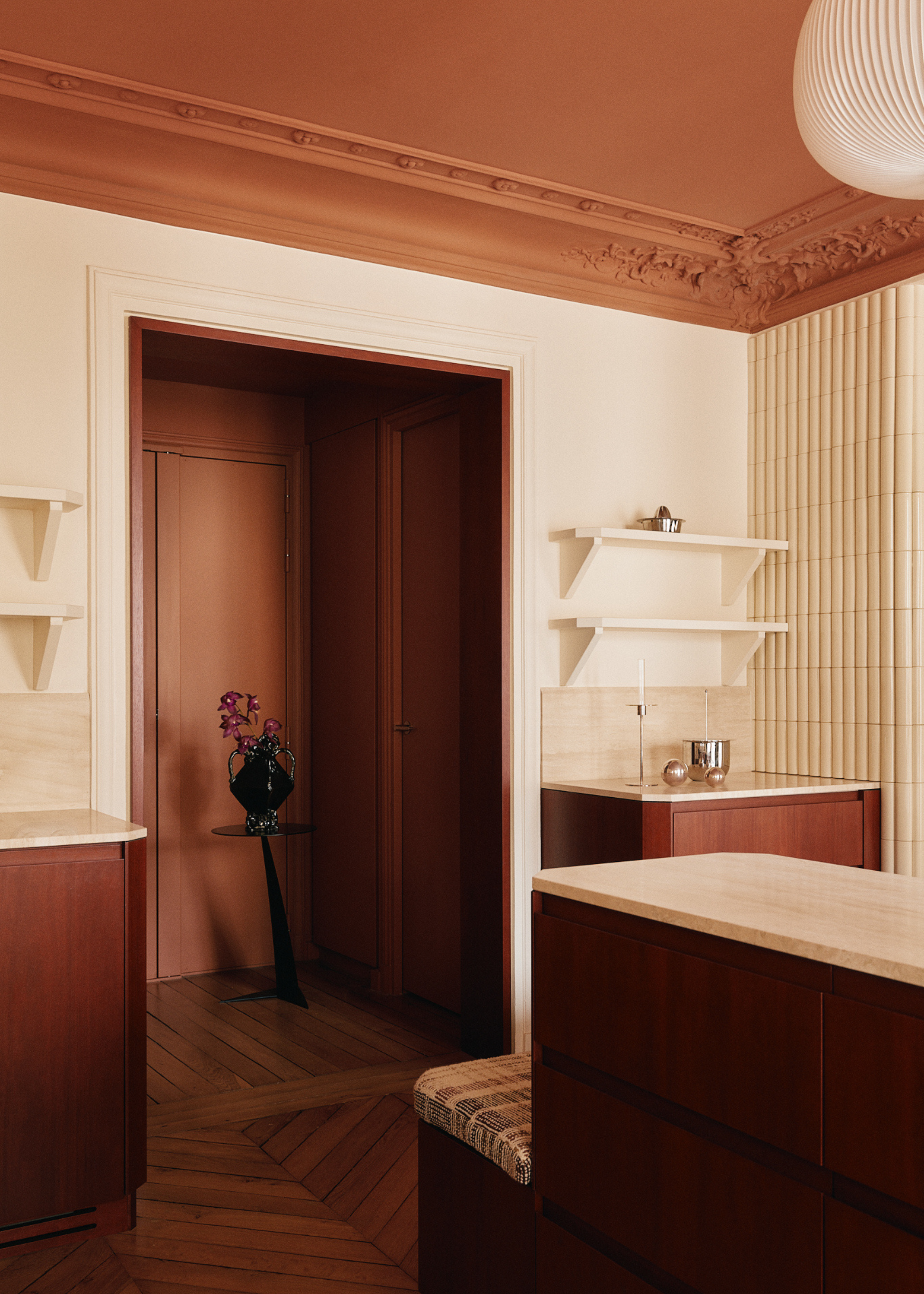 A white living room with dusty pink ceilings and wooden storage cabinetry