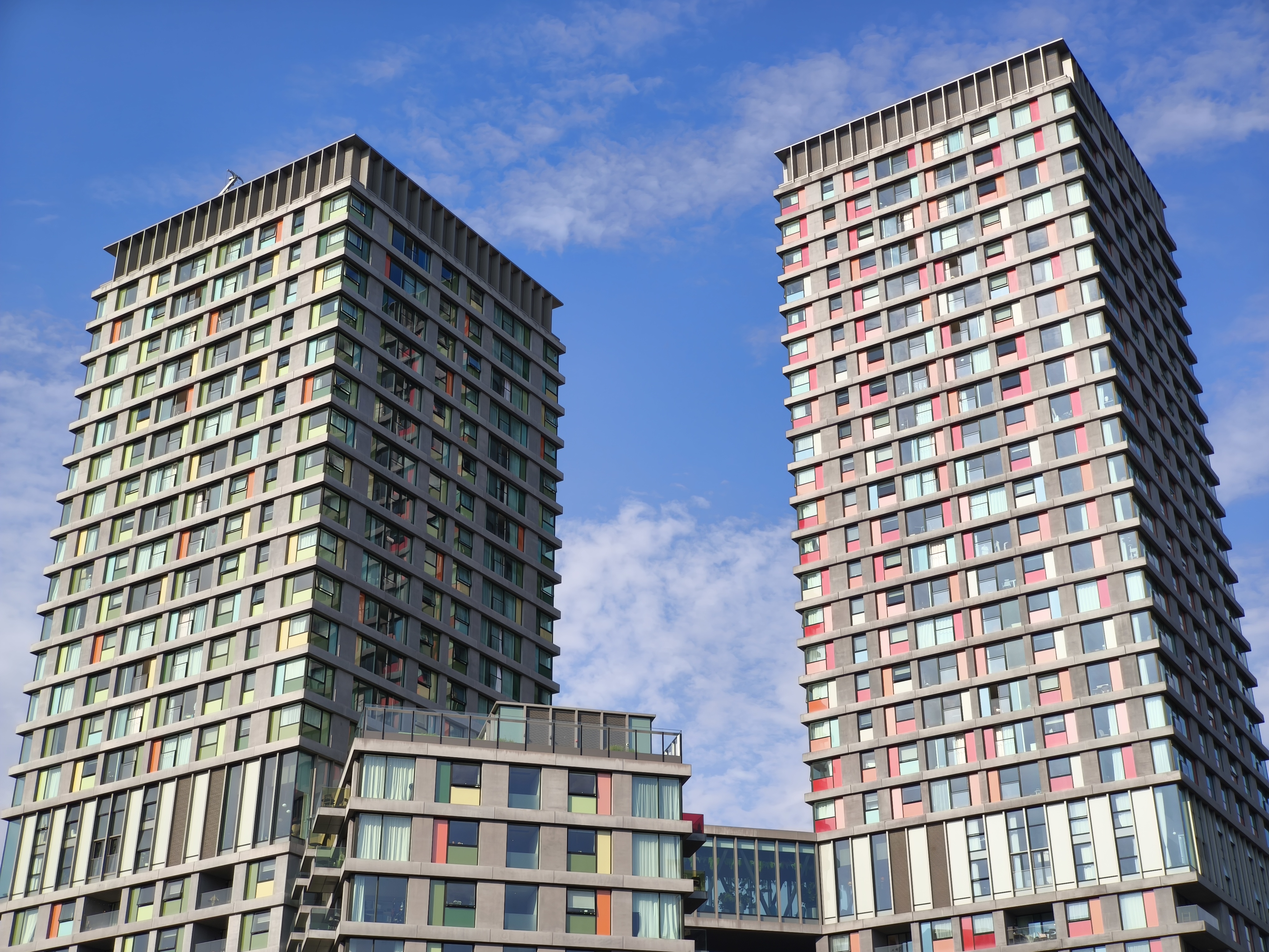 Two apartment towers against blue sky