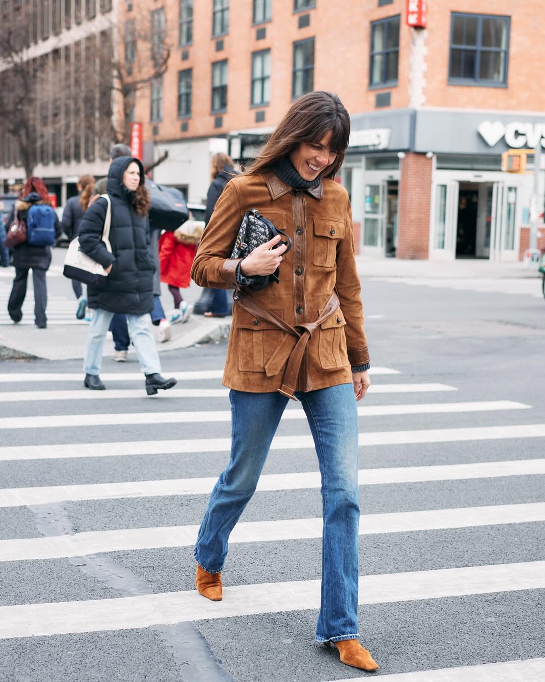Laura Vidrequin wearing bootcut jeans with a suede jacket and brown suede boots