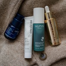 Photo of skincare products resting on a cardigan