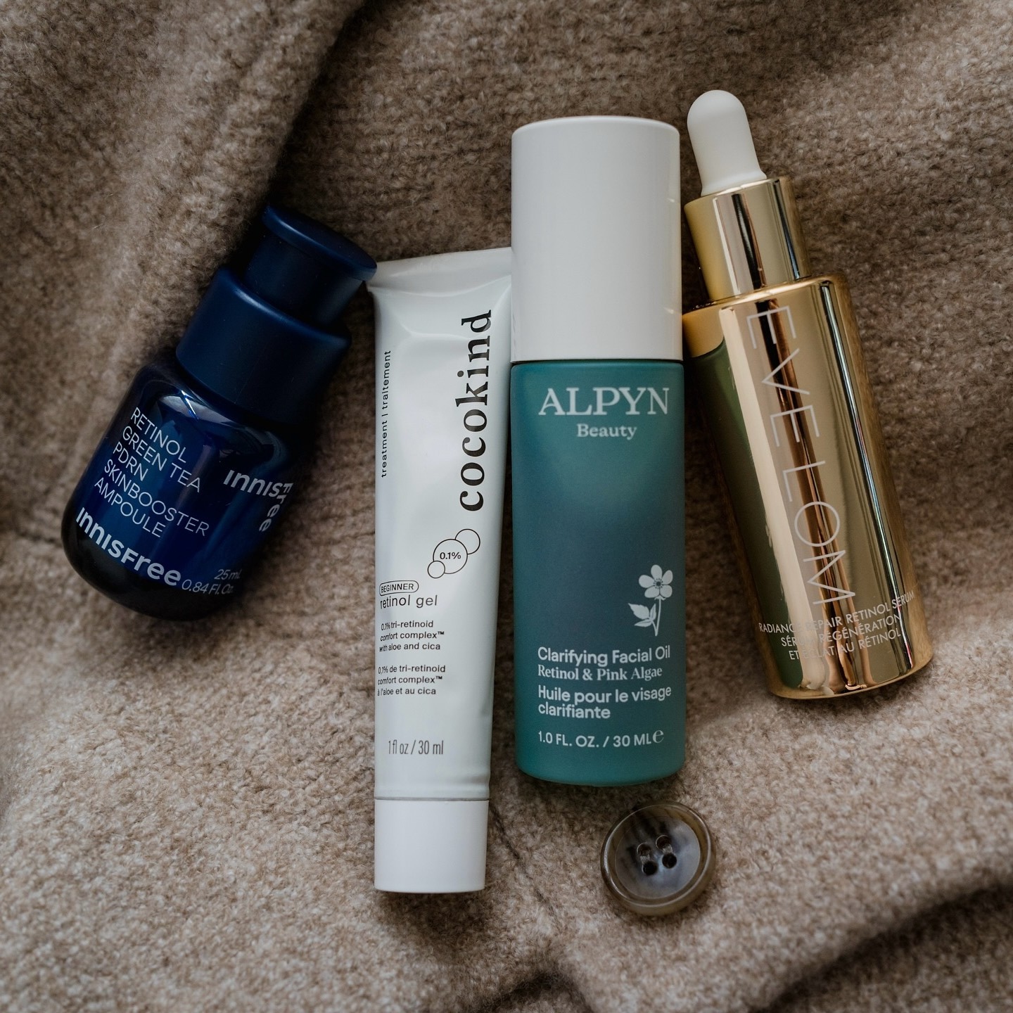 Photo of skincare products resting on a cardigan
