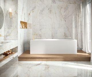 A stone drenched bathroom with marble porcelain tiles and a white square free standing bath