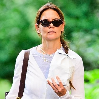 Katie Holmes wearing a white jacket, gray shirt, and wide leg jeans in New York City August 2024