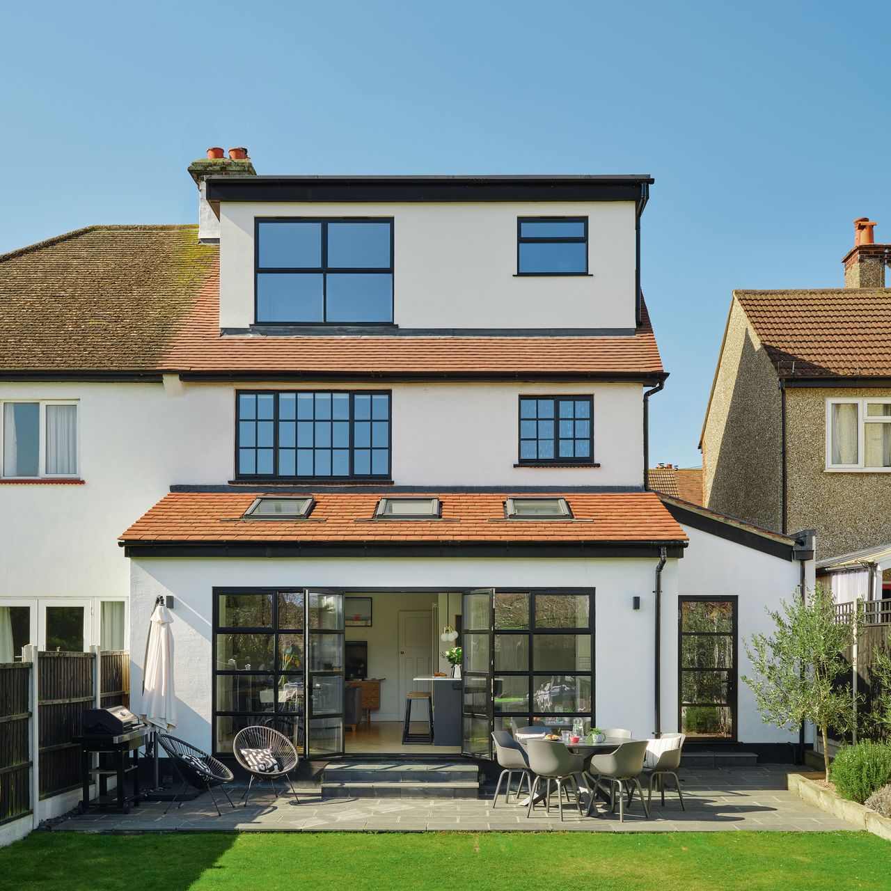 the rear view of a newly renovated three storey house