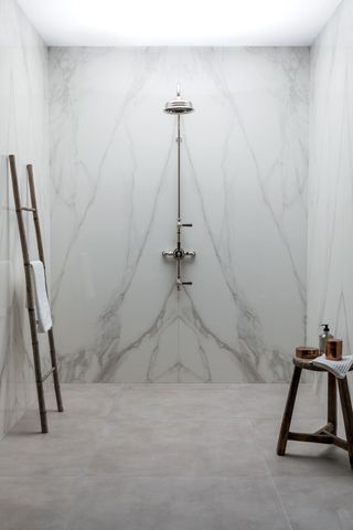a shower with a book matched marble wall