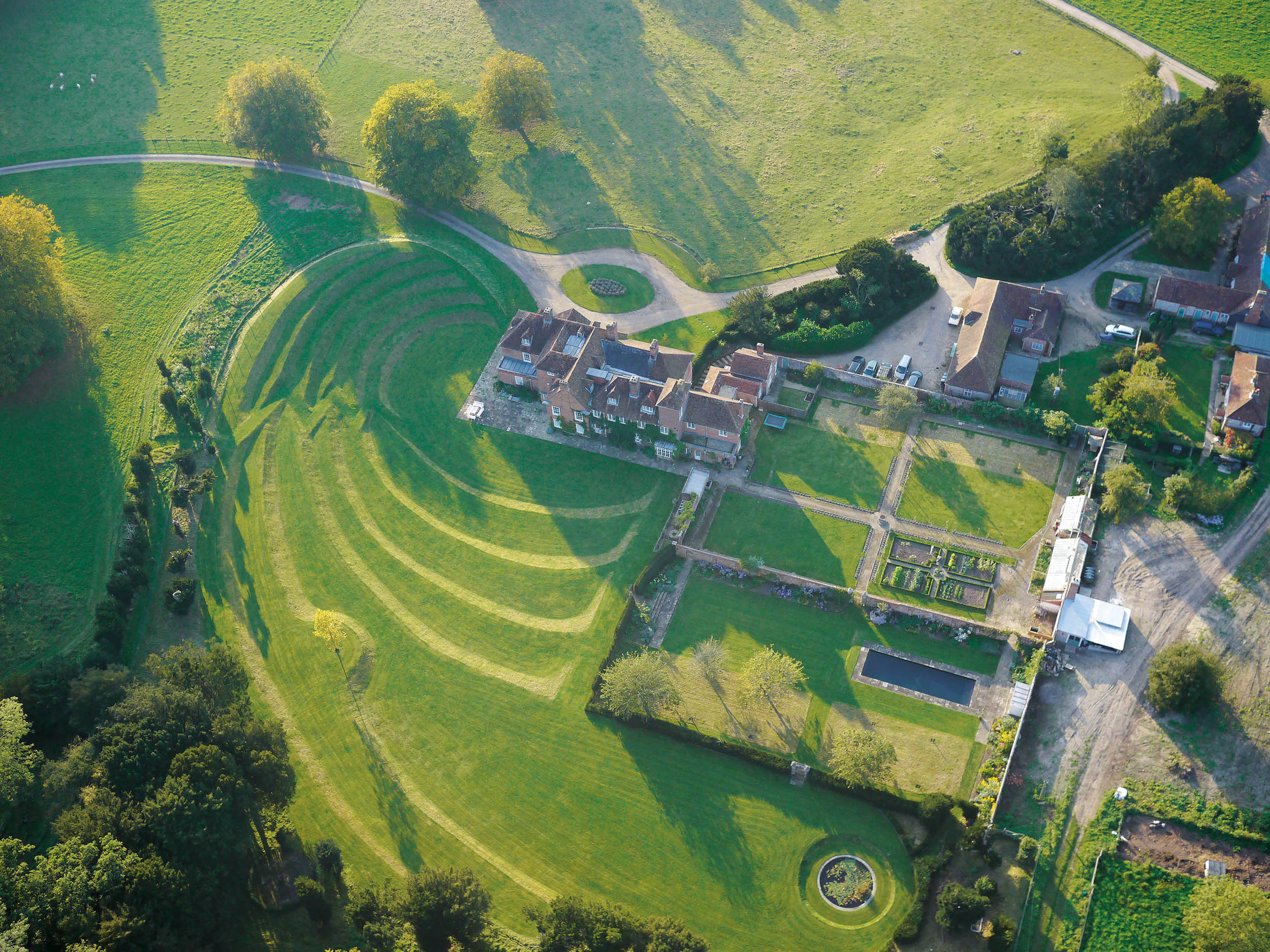 The gently curving grass terraces that were conceived by Kim Wilkie for the garden at The Holt, a 17th-century house set in the South Downs National Park &mdash; Country Life Top 100 2026