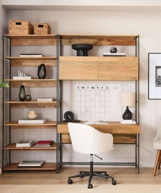 A home office with a desk with wooden shelves, a calendar, and a white chair