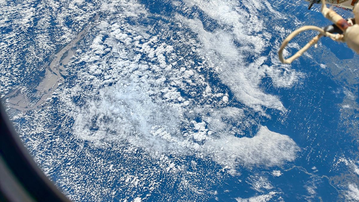 A view of clouds and sea framed by the outline of a Tiangong window.