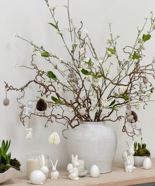 large urn vase with twigs decorated with easter ornaments