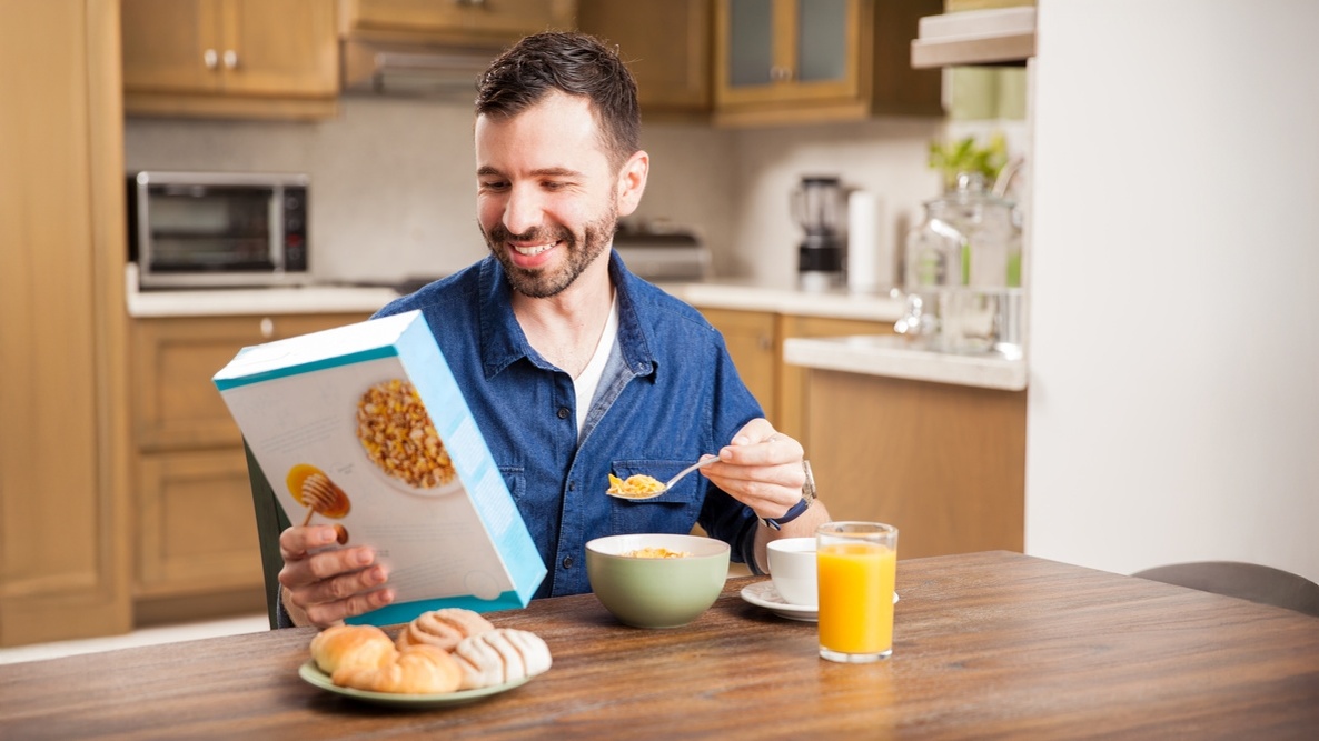 A person eating cereal against a color background