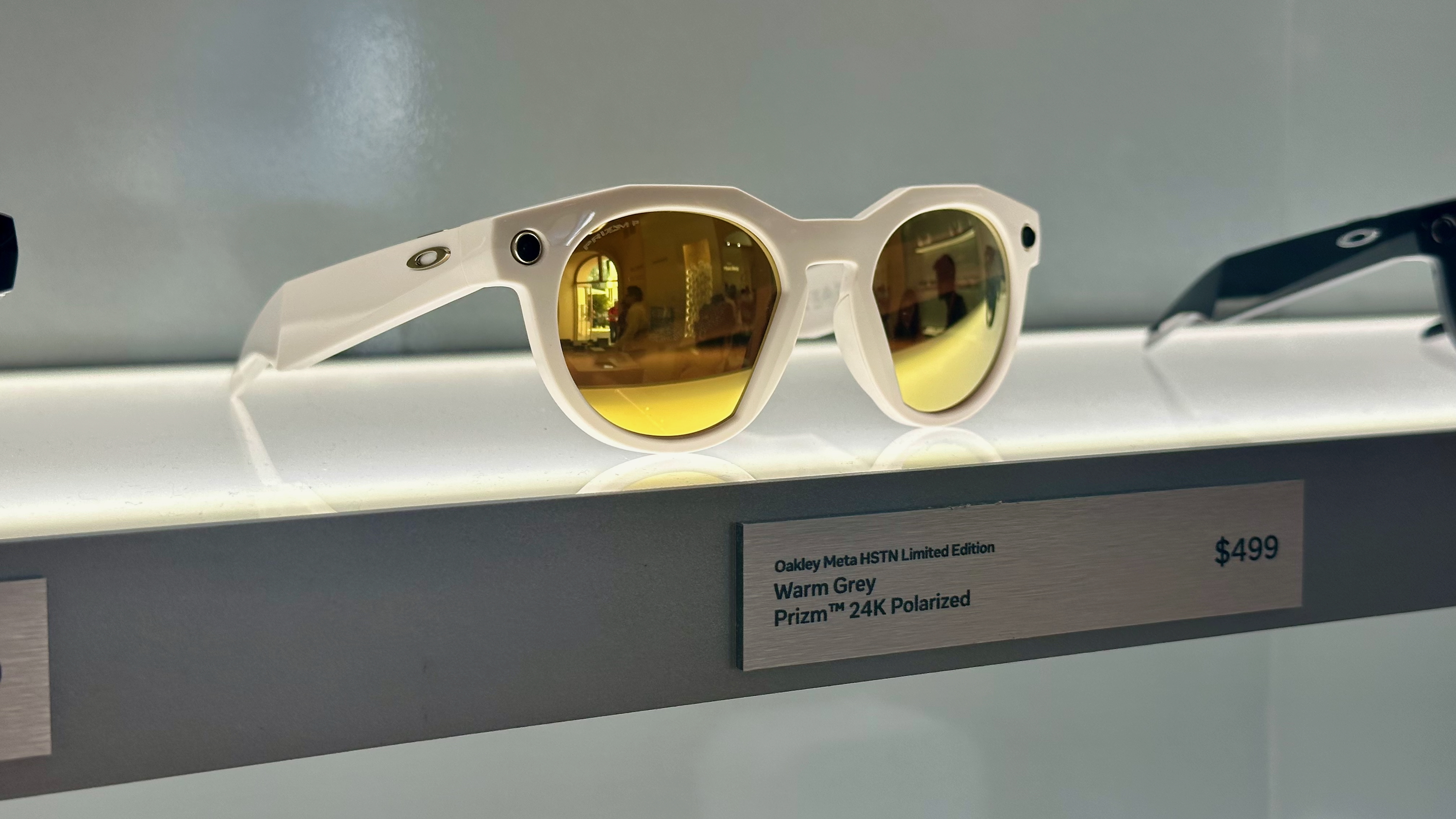 A photo of the Oakley Meta HSTN Limited Edition smart glasses in Warm Grey with Prizm 24K Polarized lenses