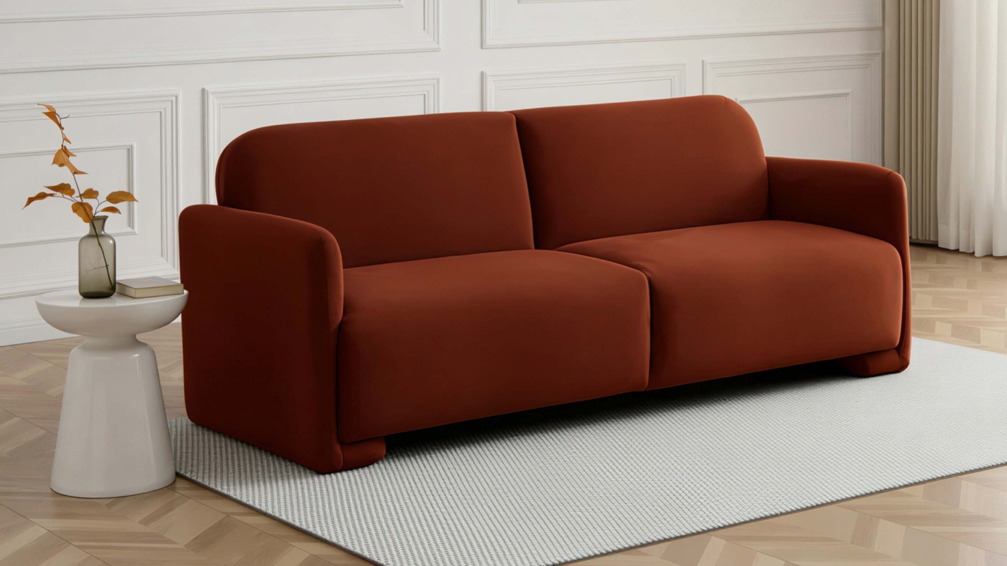 rust orange velvet sofa on a smooth grey rug