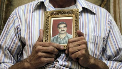 Majdi Fahmi al-Kadumi holds a picture of his brother Bashar, a reporter who disappeared in Aleppo in 2012