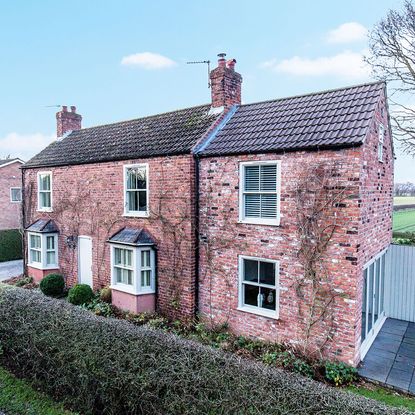 exterior of house with brick walls and white windows