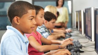 Middle school students work on desktop computers