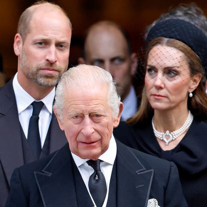 Prince William and Princess Kate stand behind King Charles while all three look serious and wear black