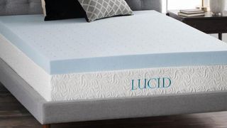 The Lucid 4 Inch gel memory foam mattress topper on a grey fabric covered bed base