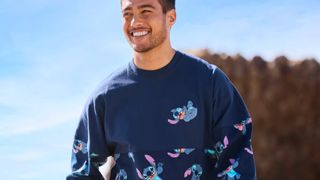 A man smiles while wearing a Stitch Spirit Jersey against blue skies