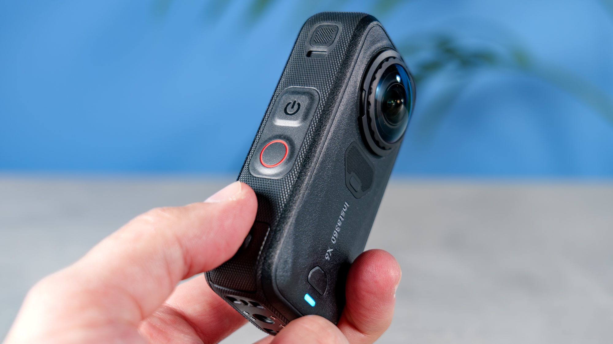 A photo of the Insta360 X6 in hand with the record and power button on display