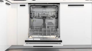 An empty and open built-in dishwasher