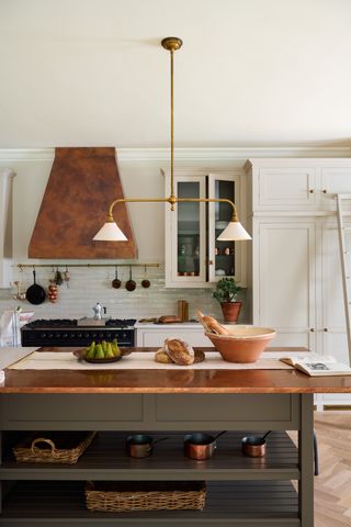 A gold/rustic kitchen island light with a white lamp shade