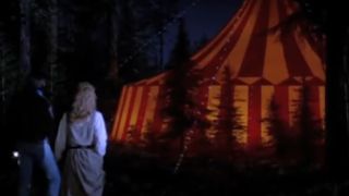 Grant Cramer and Suzanne Synder standing outside of a giant big tent in Killer Klowns From Outer Space