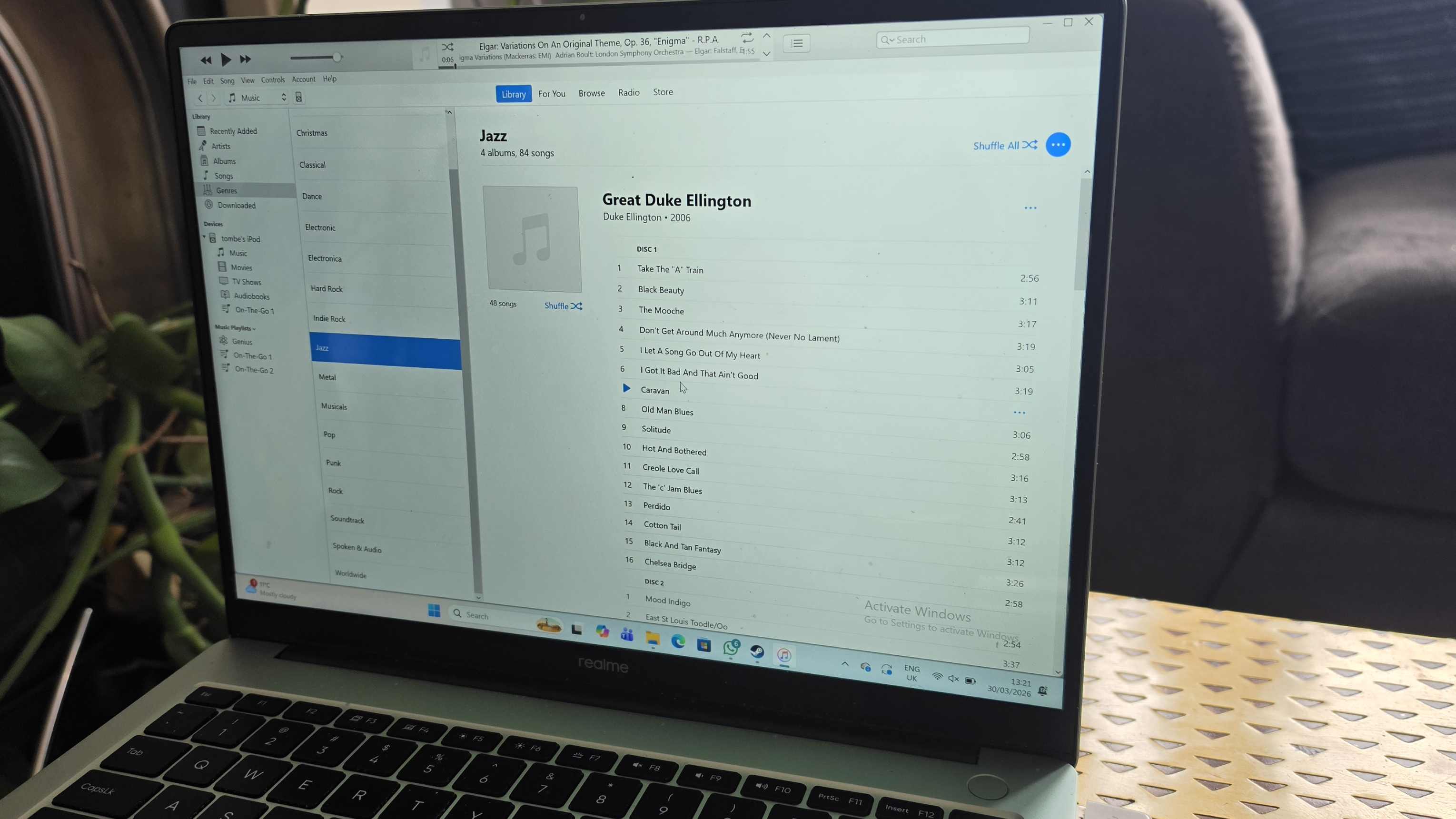 The iPod Classic connected to a green Realme laptop, showing iTunes.