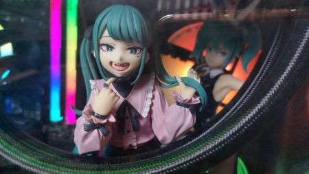 A PC with many anime figures placed inside. It looks quite crowded and impractical. The RGB lighting really makes it pop though.