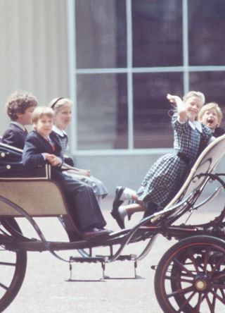 Prince William, Prince Harry, and some of their cousins riding in a carriage after Trooping the Colour