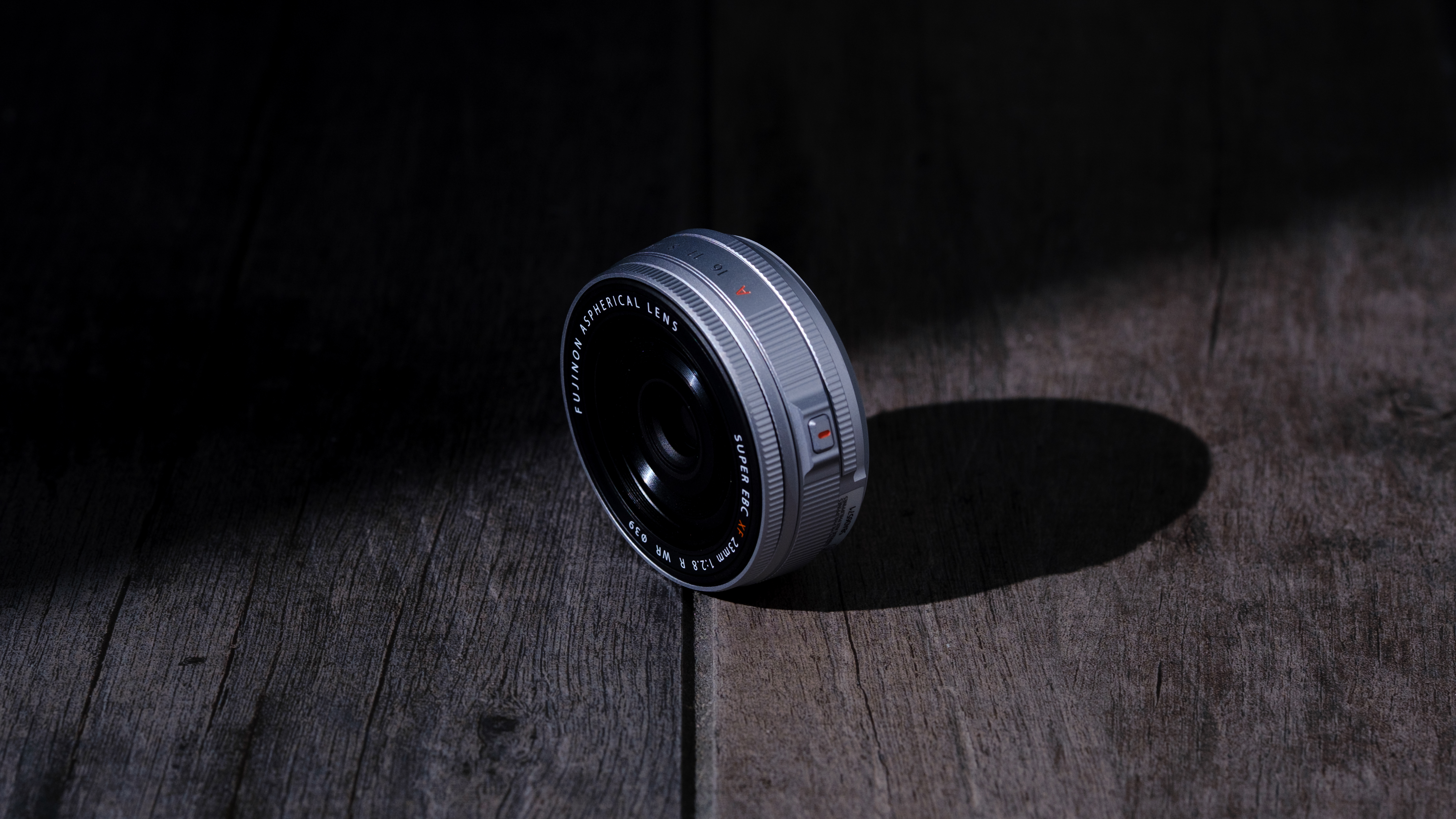 The Fujifilm XF 23mm f/2.8 R WR on a gray wood-like surface