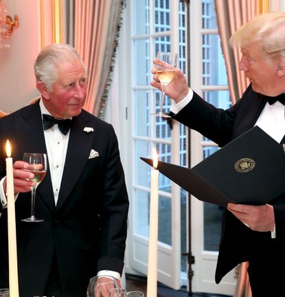 King Charles wearing a tuxedo toasting Donald Trump with wine at a 2019 dinner