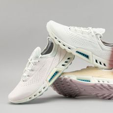 Three ECCO golf shoes in light pink, peach, and white on a grey background
