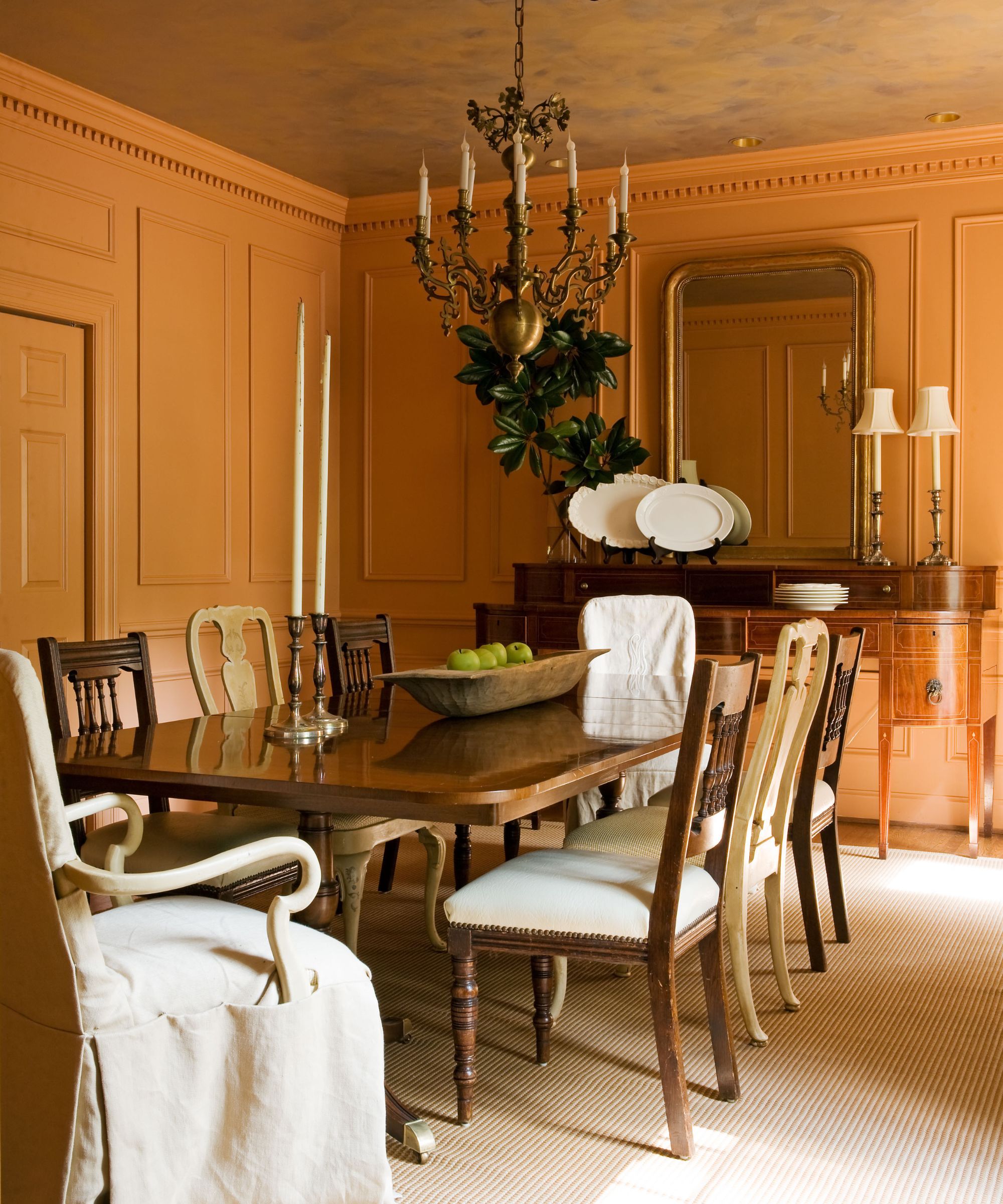 A traditional dining room with terracotta walls.