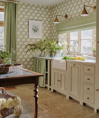 beige neutral farmhouse kitchen with a fluted sink and green foliage floral wallpaper