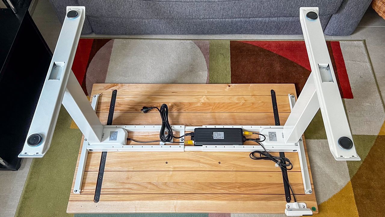 The Desky Dual Hardwood standing desk laid upside down to show the power unit under the desktop