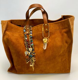 Parker Thatch suede tote bag with charms attached to the strap.