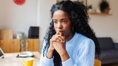 Portrait of a young woman deep in thought sitting at home